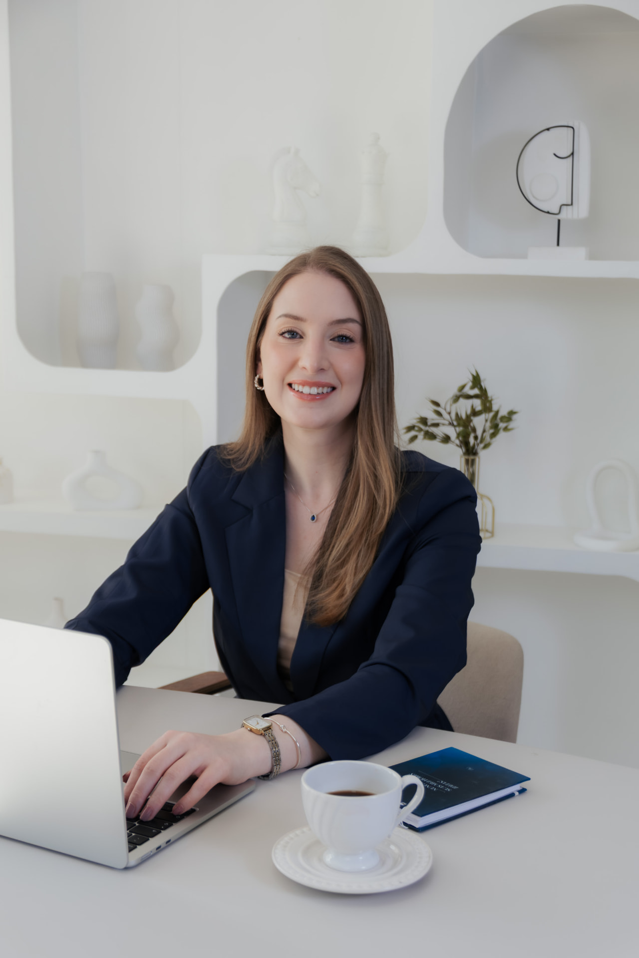 Alana Demori em seu escritório, com notebook e café